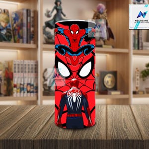 Puede incluir: Un vaso rojo y negro con gr&aacute;ficos de Spider-Man. El dise&ntilde;o incluye m&uacute;ltiples im&aacute;genes de Spider-Man, un patr&oacute;n de telara&ntilde;a y la m&aacute;scara ic&oacute;nica del personaje. El vaso cil&iacute;ndrico parece ser de acero inoxidable.
