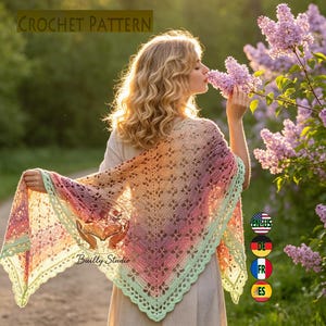 May include: A triangular crochet shawl featuring a gradient of pastel colors including pink, orange, and yellow, finished with a light green scalloped border. The openwork pattern displays a repeating diamond motif throughout the fabric.
