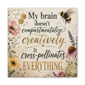 May include: A square wall art print featuring the text My brain doesn't compartmentalize creatively. It cross-pollinates EVERYTHING. The design includes a bumblebee, gold honeycomb patterns, and watercolor illustrations of pink, yellow, and purple flowers.