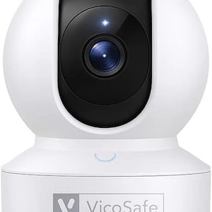 Puede incluir: Cámara de seguridad blanca con lente negro e indicador de luz azul. La cámara tiene una parte superior redondeada y una base rectangular con el texto "VicoSafe". Diseñada para la seguridad del hogar.