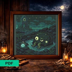 May include: A framed cross-stitch pattern featuring a pixelated dark green creature with tentacles sitting in a shallow pool of water. The scene includes a rocky landscape, a glowing orb, and a night sky with a full moon, all rendered in shades of teal.