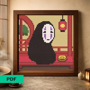May include: A framed cross-stitch featuring the character No-Face from Spirited Away. The artwork is set against a backdrop of a red archway and a yellow background, with a red lantern hanging from the top. The frame is made of dark wood.