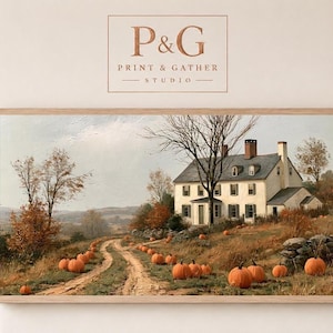 May include: A rectangular landscape painting in a light wood frame featuring a white colonial house with a chimney, surrounded by autumn trees and a dirt path lined with orange pumpkins. The text P&G PRINT & GATHER STUDIO appears above.