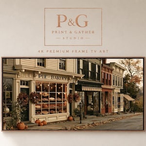 Puede incluir: Una pantalla de arte digital con una escena callejera que muestra una pastelería, follaje otoñal y calabazas en la acera. El texto P&G PRINT & GATHER STUDIO 4K PREMIUM FRAME TV ART aparece sobre la imagen horizontal enmarcada.