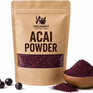 May include: A brown paper pouch labeled VEDAMRIT ROOTS NATURALS ACAI POWDER with a clear window showing deep purple powder. Next to the pouch is a wooden bowl filled with the same purple powder and four small, round, dark purple acai berries.