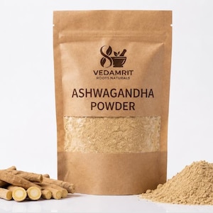 Może przedstawiać: Brązowa torebka z papieru pakowego z etykietą VEDAMRIT ROOTS NATURALS ASHWAGANDHA POWDER i przezroczystym okienkiem ukazującym jasnobrązowy proszek. Obok torebki leżą kawałki zdrewniałych korzeni oraz mały kopczyk drobnego, jasnego proszku.