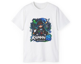 May include: A white short-sleeve t-shirt featuring a graphic of a hooded character wearing sunglasses and using a laptop. The design includes a penguin, a rocket, computer screens with text reading CREATE, BUILD, EXPLORE, YEET, and KAIMAN 18 STUDIOS.
