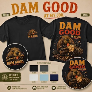 May include: A black t-shirt featuring a graphic of a beaver chewing on a log with the text DAM GOOD AT MY JOB. The design appears on the front left chest and as a larger print on the back. Six colour options are displayed including black, pepper, ivory, white, chambray, and true navy.