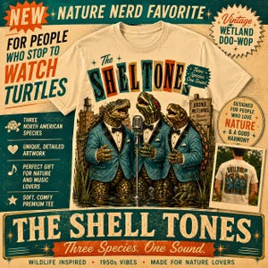 May include: A cream-coloured t-shirt featuring a graphic of three turtles in blue suits singing into a microphone. The text reads The Sheltones, Three Species One Sound, and Bronx Wetlands. The design includes a vintage-style advertisement layout.