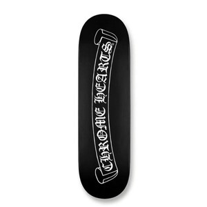 May include: Black skateboard with a white banner design. The banner features the text "CHROME HEARTS" in a gothic font. The skateboard has a rounded shape and is set against a white background.