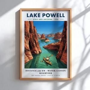 May include: A framed travel poster of Lake Powell, Utah and Arizona, USA. The illustration depicts a person in a yellow kayak on blue water between red rock canyons. Text includes: LAKE POWELL, DISTANCE 299 KM, WATER: CANYON RESERVOIR, BEST SEASON: APR-OCT.