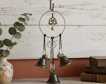Campanilla de viento antigua de metal con campanas y símbolo celta para decoración vintage del hogar.