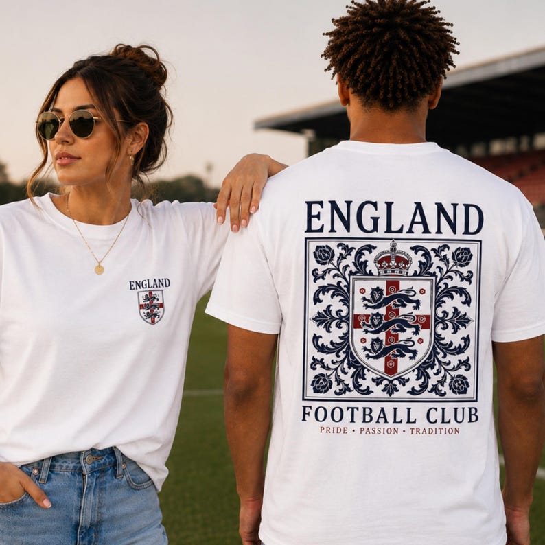 A woman and man wearing white England football club t-shirts standing on a grass field.