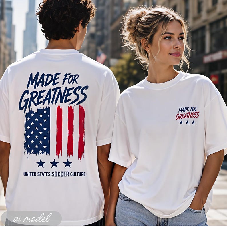 以下が含まれることがあります： 背面に「MADE FOR GREATNESS」の文字と様式化されたアメリカ国旗、「UNITED STATES SOCCER CULTURE」の文字が大きくプリントされ、胸元には小さな文字と3つの星がデザインされた白いTシャツ。