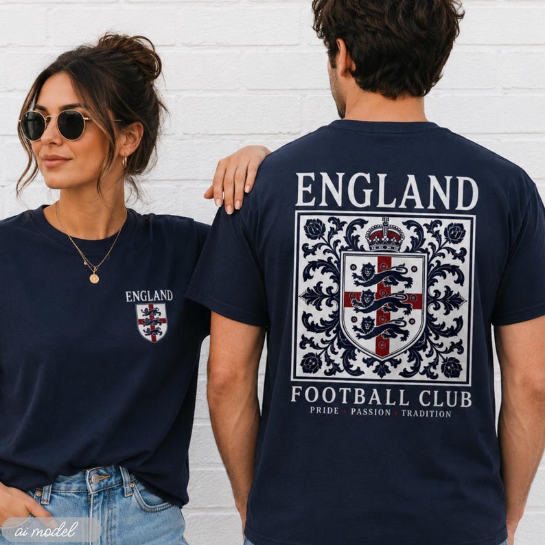 A woman and man wearing dark blue England football club t-shirts outdoors against a white wall.