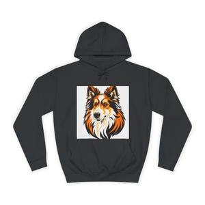 Op de afbeelding: Een zwarte hoodie met een hondenafbeelding. Het gezicht van de hond is afgebeeld in een vierkant, met bruin, oranje en wit haar. De hoodie heeft een capuchon met trekkoord en een voorzak.
