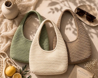 May include: Three crochet handbags in sage green, cream, and tan colors. Each bag features a rounded hobo shape with a single integrated handle and a consistent horizontal ribbed texture throughout the exterior surface of the woven material.