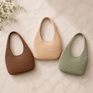 Peut inclure: Trois sacs &agrave; main de style hobo r&eacute;alis&eacute;s avec un point de crochet dense. Les sacs sont pr&eacute;sent&eacute;s en trois couleurs unies distinctes : un brun chocolat profond, un beige clair et un vert sauge att&eacute;nu&eacute;. Chaque sac poss&egrave;de une anse int&eacute;gr&eacute;e.