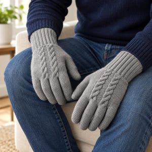 May include: A pair of light gray knit gloves featuring a vertical cable knit pattern on the back of the hand and a ribbed cuff. The gloves are constructed from a soft, textured yarn and provide full coverage for the fingers and palms.