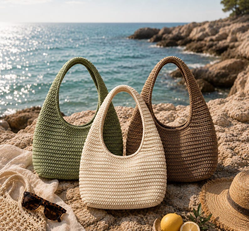 Peut inclure: Trois sacs &agrave; main de style hobo fabriqu&eacute;s en fil crochet&eacute; de couleur vert olive, cr&egrave;me et marron. Chaque sac pr&eacute;sente une anse int&eacute;gr&eacute;e unique et une base arrondie. Les sacs sont dispos&eacute;s ensemble, mettant en valeur leur texture c&ocirc;tel&eacute;e.