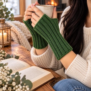 May include: A pair of forest green fingerless gloves featuring a vertical ribbed knit pattern. The gloves extend from the knuckles to the mid-forearm, providing coverage while leaving the fingers and thumbs exposed for dexterity and ease of movement.