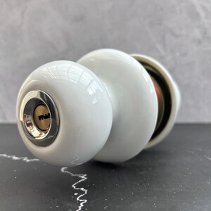 Dörrknoppset i vitt jadeporslin med nyckel, låsset i vintagestil