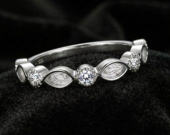 Op de afbeelding: Een zilverkleurige ring met een herhalend patroon van ronde, heldere, gefacetteerde stenen die afwisselen met marquisevormige, getextureerde zilveren zettingen. De binnenkant van de ring is duidelijk gestempeld met het keurmerk 925.
