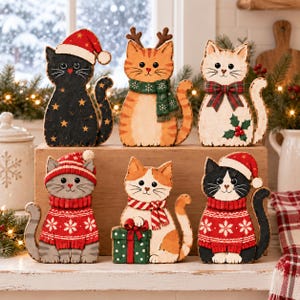 May include: A set of six decorative wooden cat figurines featuring holiday themes. The cats are painted in various colors including black, orange, white, and gray, and are adorned with Santa hats, scarves, reindeer antlers, and a gift box.