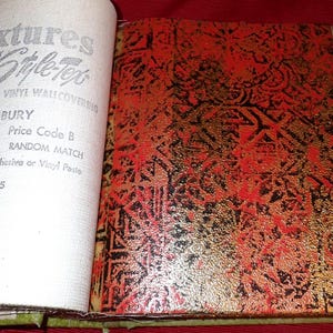May include: An open sample book page featuring text that reads textures by Style-Tex, FABRIC-BACKED VINYL WALLCOVERING, BAMBURY, T-3530, 27 TRIMMED, RANDOM MATCH, Use Only Style-Tile Adhesive or Vinyl Paste, PAGE 55. Beside it is a red and black patterned vinyl.