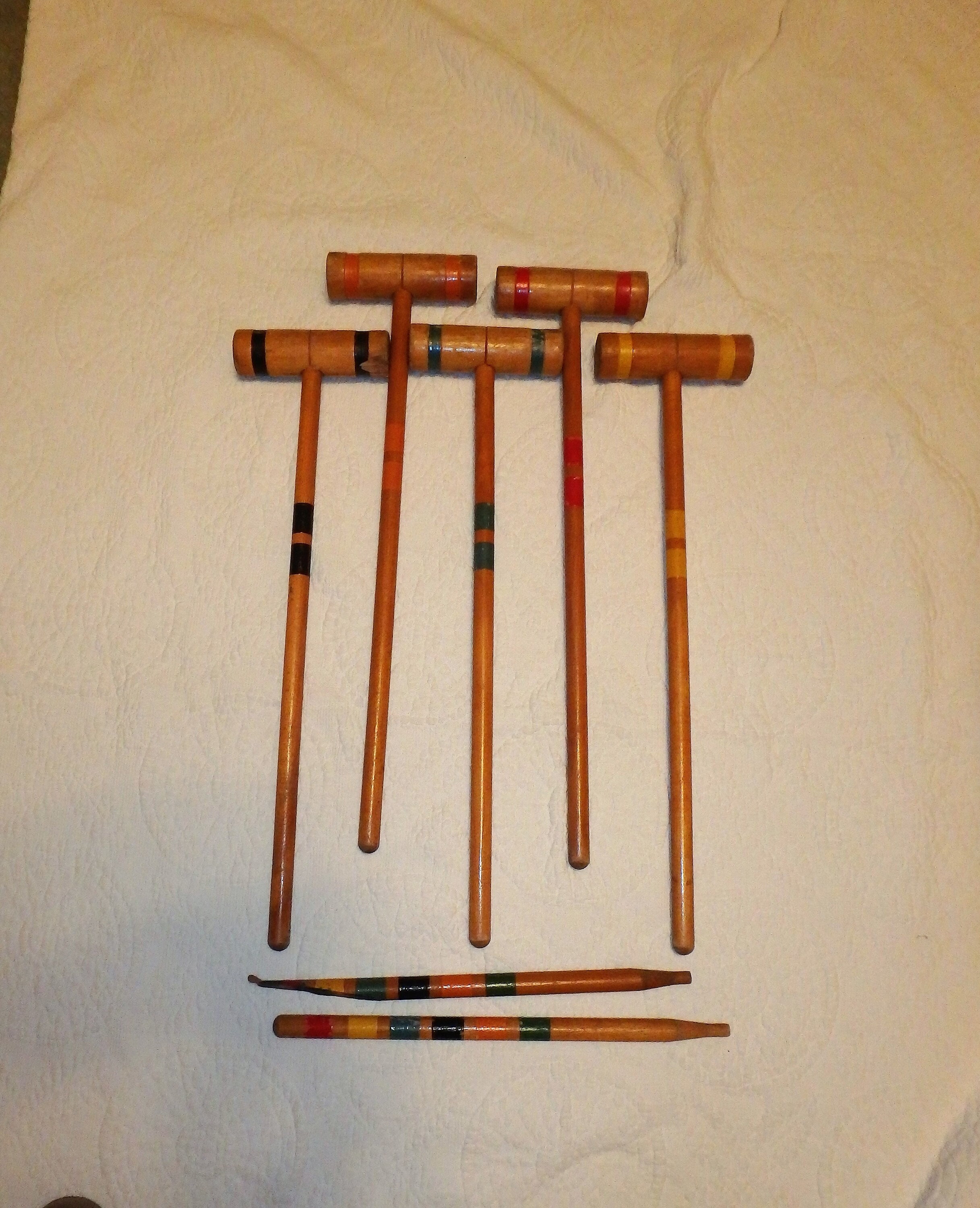 Five Croquet Mallets And Two Stakes