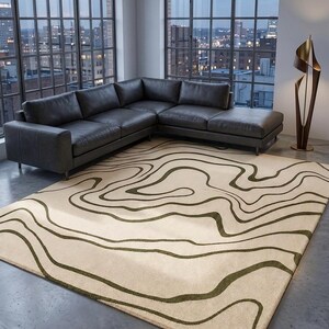 May include: A rectangular area rug featuring a cream-coloured base with dark olive green wavy, organic lines that mimic topographic map contours. The rug is positioned on a concrete floor in front of a large sectional sofa and a tall floor lamp.