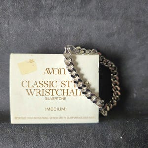 Può includere: Un braccialetto a catena da polso Avon Classic Style argentato di medie dimensioni. Il braccialetto è in stile catena a maglia. Il braccialetto è esposto con la sua confezione originale, che include il logo Avon e le informazioni sul prodotto.