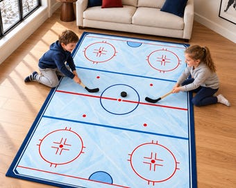 Puede incluir: Una alfombra rectangular con un diseño de pista de hockey sobre hielo en azul claro, con círculos de saque rojos, líneas azules y una línea central roja. La alfombra incluye un disco negro en el centro y un borde azul oscuro.