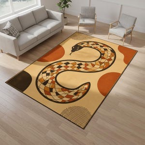 Op de afbeelding: Een rechthoekig vloerkleed met een gestileerd slangenontwerp in bruin, oranje en zwart op een beige achtergrond. Het kleed heeft een geometrisch patroon, oranje cirkels en een zwarte rand. De afmetingen van het kleed zijn in centimeters.