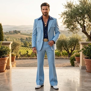 Puede incluir: Un traje azul claro que incluye una chaqueta con dos bolsillos en el pecho y dos bolsillos inferiores, junto con pantalones acampanados a juego. Se combina con una camisa azul marino de cuello ancho, collares dorados y una hebilla de cinturón grande.