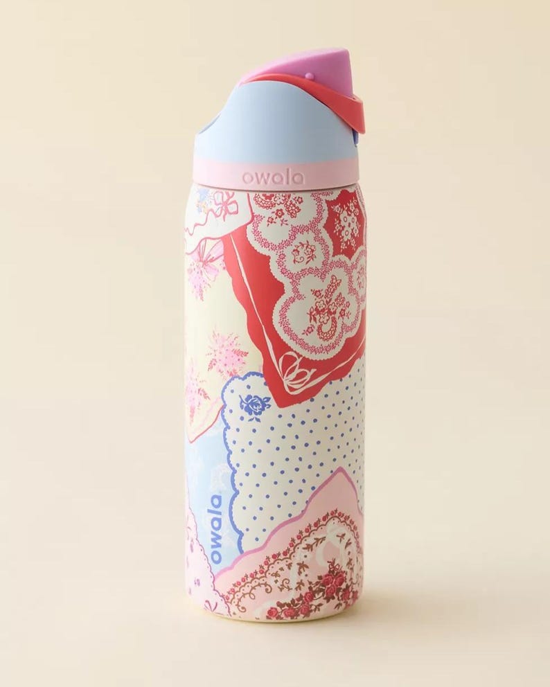 May include: A colorful Owala water bottle with a floral pattern in red, pink, and blue. The bottle has a light blue lid and a pink top. The word "owala" is printed on the bottle.