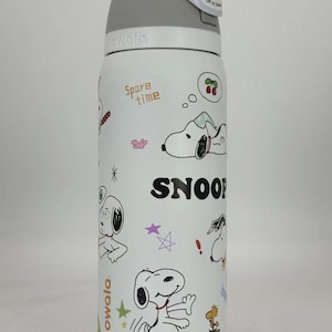 May include: White Owala water bottle featuring Snoopy illustrations and the word "SNOOP". The bottle has a gray lid with a white carrying strap. The words "Spare time" are also printed on the bottle.