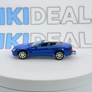 Può includere: Un'auto giocattolo decappottabile blu in metallo pressofuso con interni dettagliati, ruote argentate a più razze e un tubo di scarico posteriore. Il veicolo è posizionato di profilo, mostrando le sue linee eleganti su una superficie bianca.