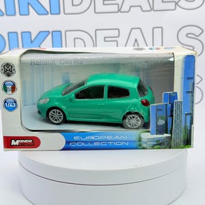 Può includere: Un modellino in scala 1/43 di una Renault Clio RS verde nella sua confezione originale. La scatola riporta la scritta Renault Clio RS, European Collection e Mondo Motors, con un grafico di grattacieli sul lato destro.
