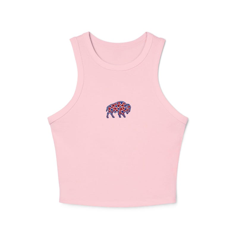 May include: A light pink crop top with a high neckline. The top features a small embroidered bison design on the front, filled with red and blue stars. The top is made of a soft, comfortable material.