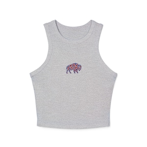 May include: A light gray crop top with a small embroidered buffalo design. The buffalo is filled with red and blue stars. The top has a rounded neckline and sleeveless design.