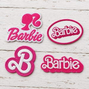 May include: Four embroidered fabric patches featuring the Barbie logo and silhouette. One patch shows the Barbie profile silhouette with text, one is an oval with the logo, one is a large letter B, and one is the Barbie script logo.