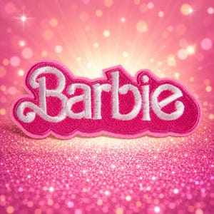 May include: A hot pink embroidered patch featuring the word Barbie in white cursive script lettering. The patch has a thick pink stitched border and a textured fabric surface, set against a bright pink background with a sparkling glitter effect.