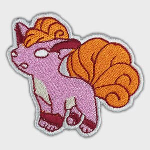 May include: An embroidered patch featuring a stylized creature with light pink fur, a cream-colored chest, and dark red paws. The creature has a large, curled orange tail and orange hair on its head, all outlined with a white border on a light background.