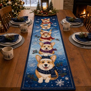 Puede incluir: Camino de mesa azul con un patrón repetido de perros corgi sonrientes con gorros y bufandas de invierno. El camino de mesa está decorado con copos de nieve y ramitas de vegetación, creando un tema festivo navideño.
