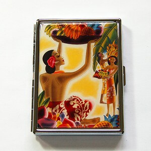 Op de afbeelding: Een zilveren sigarettenetui met een kleurrijke illustratie van Polynesische vrouwen en tropisch fruit. Eén vrouw balanceert een fruitmand, een andere houdt een kind vast. De achtergrond is geel met groene bladeren.