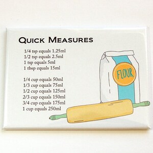 May include: A rectangular kitchen magnet with the text "QUICK MEASURES" and conversion charts for teaspoons, tablespoons, and cups to millilitres. The magnet features a flour sack, rolling pin, and the word "FLOUR".