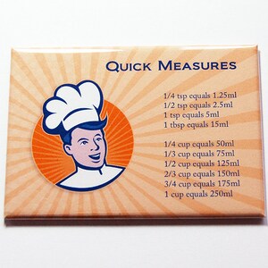 May include: A rectangular magnet with a retro design featuring a chef illustration and the words "Quick Measures." The magnet lists common kitchen measurements, including teaspoons, tablespoons, and cups, with their metric equivalents in millilitres.