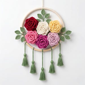 May include: A handcrafted floral wall hanging featuring a wooden hoop adorned with crocheted roses in shades of red, pink, yellow, and cream. Green leaves and tassels add detail to this decorative piece. The diameter of the hoop is approximately 8 inches.