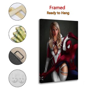 May include: A framed canvas print featuring a blonde character in a white and red suit standing beside a red and blue costumed character with a spider emblem. The text reads Framed Ready to Hang. Includes wooden frame, canvas texture, and hanging hardware.